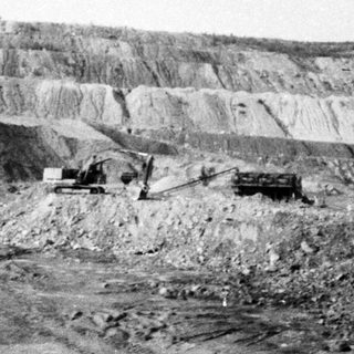 Open-pit mining excavation with heavy machinery.