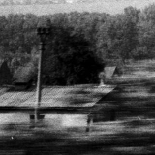 Rural landscape with farmhouses and open fields.