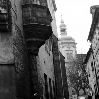 Historic European street with old architecture and church dome.