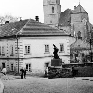 Historic town square with clock tower and statue.