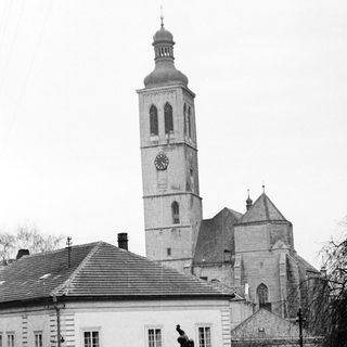 Historic town square with clock tower and statue.