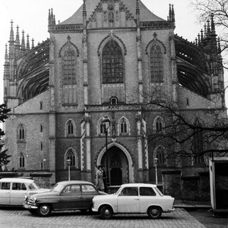 Gothic-style cathedral with pointed arches and vintage cars.