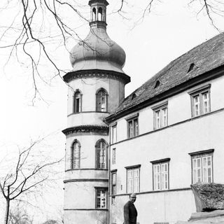 A man standing near a historic building with a dome.