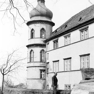 A man standing near a historic building with a dome.