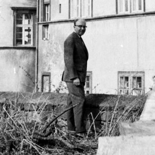 A man standing near a historic building with a dome.