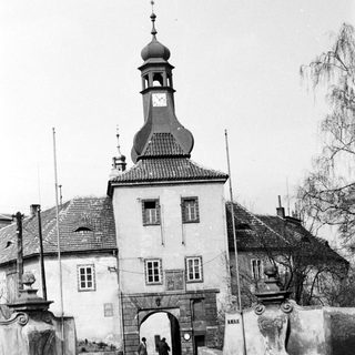 Historic town gate with clock tower and archway.