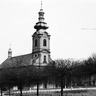 Historic church with tall steeple in park-like setting.