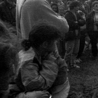 Group of people gathered outdoors in a rural setting.