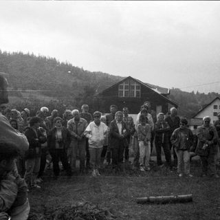 Group of people gathered outdoors in a rural setting.
