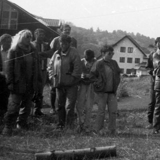 Group of people outdoors in rural setting, posing for a photo.