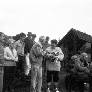 Group of people outdoors receiving certificates or documents.
