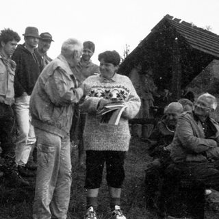 Group of people outdoors receiving certificates or documents.
