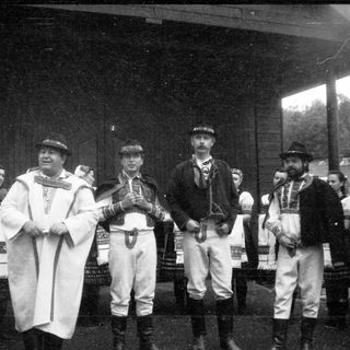Traditional folk ensemble in regional costumes performing outdoors.