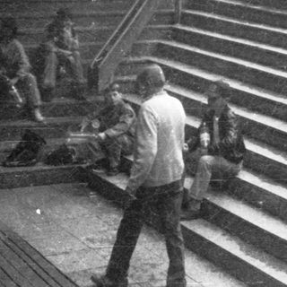 People gathered on wide stairs during an outdoor event.