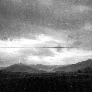 Mountain range under cloudy sky with power line.