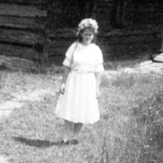 Traditional wooden church with woman standing outside.