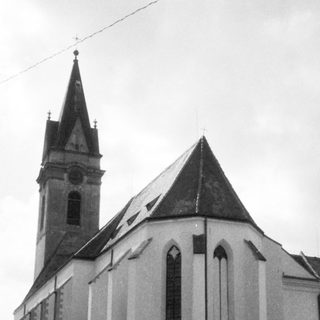 Historic church with steep spire and pointed arches.
