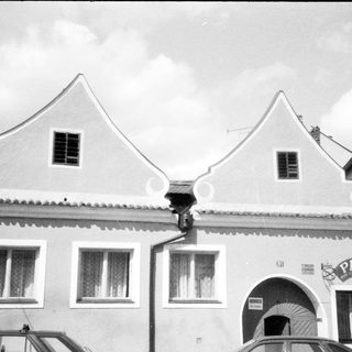 Traditional European building with gabled roof and "Pizzeria" sign.