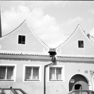 Traditional European building with gabled roof and "Pizzeria" sign.