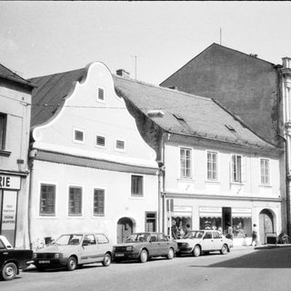 Historic European street with classic buildings and parked cars.
