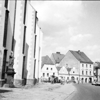 Historic European town square with church and pedestrians.