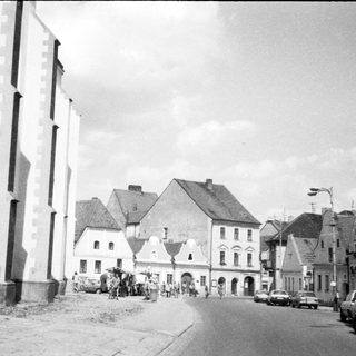 Historic European town square with church and pedestrians.
