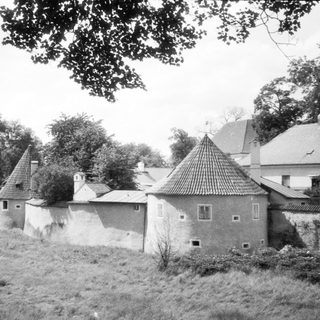 Rural buildings with conical and sloped roofs.