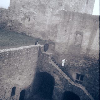 Historic stone fortress with narrow walkway and guards.