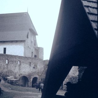 Medieval fortress courtyard with stone walls and archways.