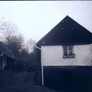 Rural houses with sloped roofs, bare trees.