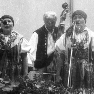 Traditional folk musicians performing with instruments.