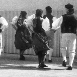Traditional folk dancers performing outdoors in cultural attire.