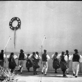 Traditional folk dancers performing outdoors in cultural attire.