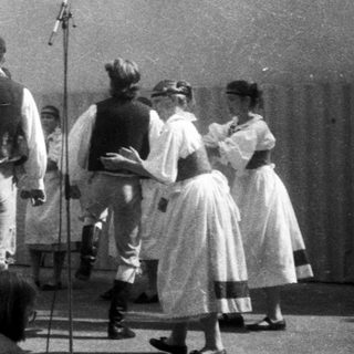 Traditional folk dance with musicians and dancers in regional attire.