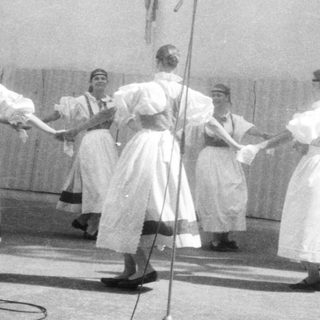 Group performing traditional folk dance with hand-holding.