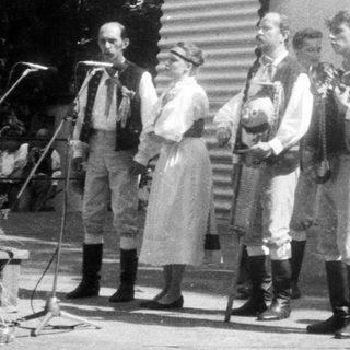 Traditional folk band performing outdoors in folk costumes.