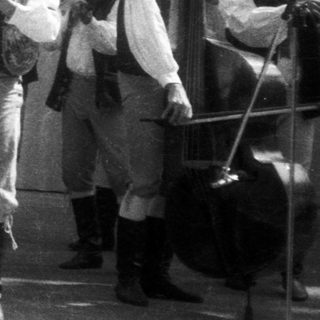 Traditional folk band performing with singer in regional attire.