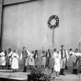 Group performing traditional folk songs outdoors.