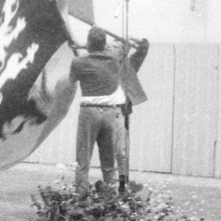 Ceremony with flag raising and wreath presentation.
