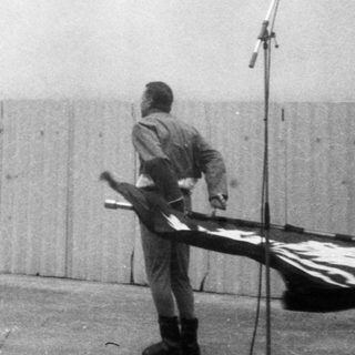 Ceremony honoring with flag and wreath.