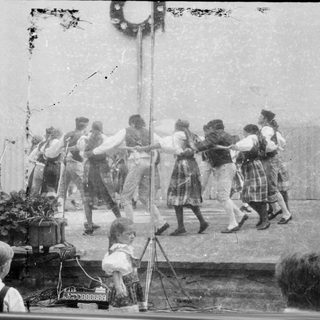 Children participating in a traditional rope-pulling game outdoors.