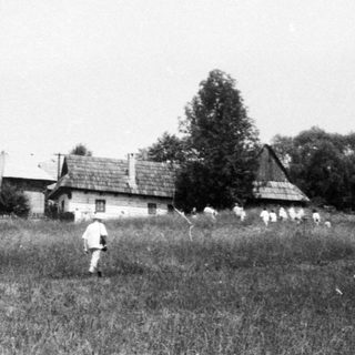 Children playing soccer in rural field near mountains.