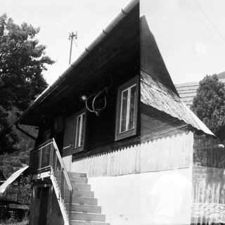 Traditional wooden house with steep roof and stairs.