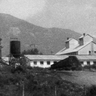 Rural landscape with hills, farmland, and house.