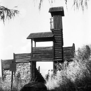 Rustic wooden lookout tower with stone base.