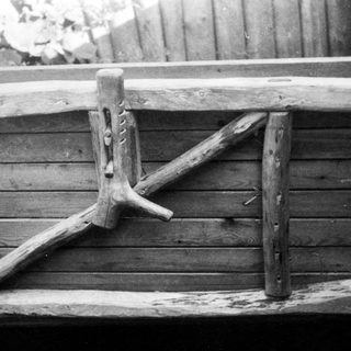 Rustic wooden ladder leaning against barn door.