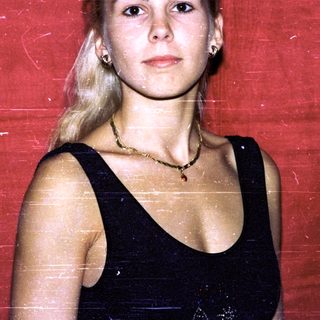 Young woman with blonde hair in black dress.