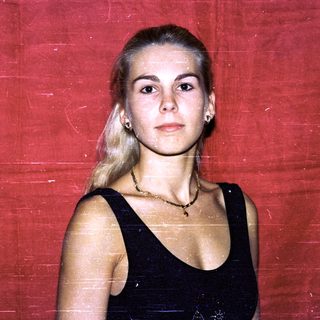 Young woman with blonde hair in black dress.