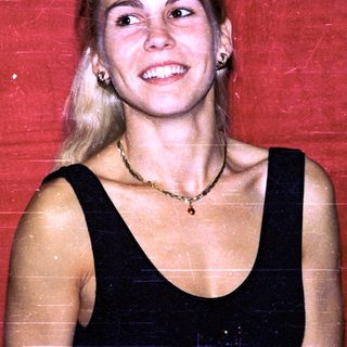 Blonde woman smiling in black top.