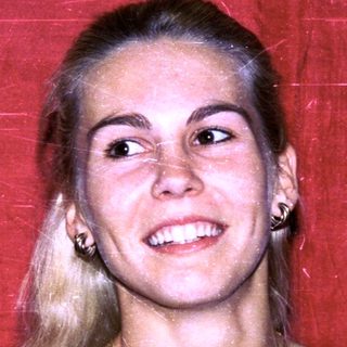 Blonde woman smiling in black top.